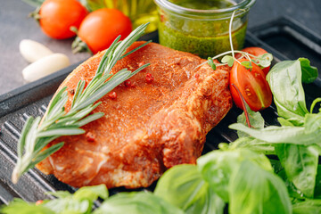 raw pork steak in spices and olive oil and basil dressing