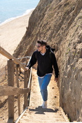 Young stylish man hiking in the rocks with a beautiful nature chasing new adventure 