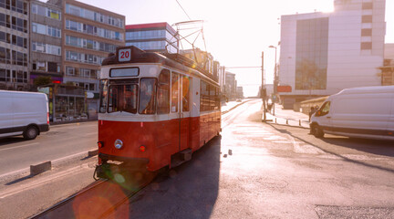 red tram in the street. empty streets and light reflections at sunrise