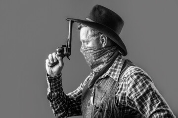 West, guns. Portrait of a cowboy. American bandit in mask, western man with hat. Portrait of cowboy in hat. Portrait of man wearing cowboy hat, gun. Portrait of a cowboy. Black and white