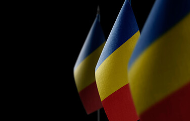 Small national flags of the Romania on a black background
