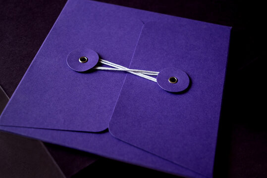 Envelope tied with white string wound between two clasps close up