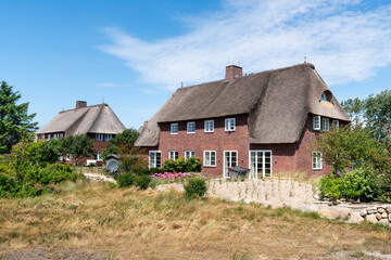 Fototapeta na wymiar Traditional thatched roof houses on the island of Sylt, Schleswig-Holstein, Germany