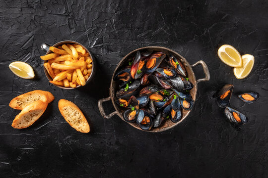 Mussels, overhead shot with French fries, lemon, and toasted bread