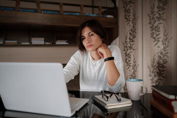 Beautiful asian young woman working on laptop computer while sitting at the living room.