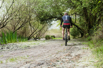Naklejka premium middle-aged man mountain biking in a wonderful setting