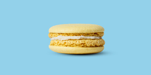 Yellow lemon macaron isolated on a pastel blue background. with a shadow.