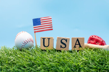 Baseball with flag of America and USA wooden block on green grass for 4th July Independence day