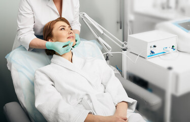 Facial ozone therapy. Woman during rejuvenation skin face with ozone therapy procedure - obrazy, fototapety, plakaty