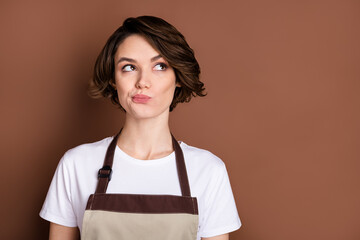 Photo of pretty focused girl look interested empty space thinking planning isolated on brown color background