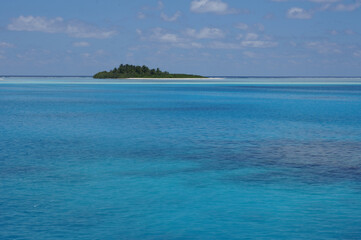 Fototapeta premium Uninhabited tropical island with palm trees. empty space with beautiful turquoise lagoon
