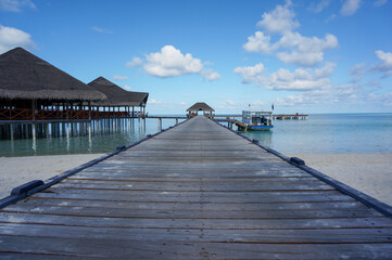 Wooden pier leading to diving boat on indian ocean in the Maldives. turquoise lagoon