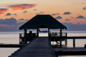 landing of a seaplane on the maldivian lagoon at sunset. luxurious travel concept