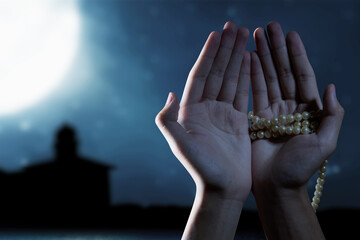 Muslim man praying with prayer beads on his hands