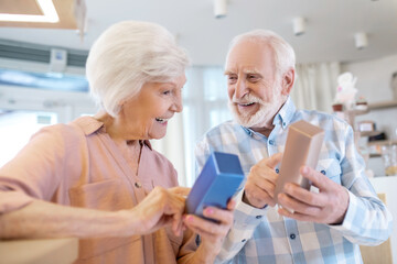 Obraz premium Gray-haired couple choosing perfumes and looking excited
