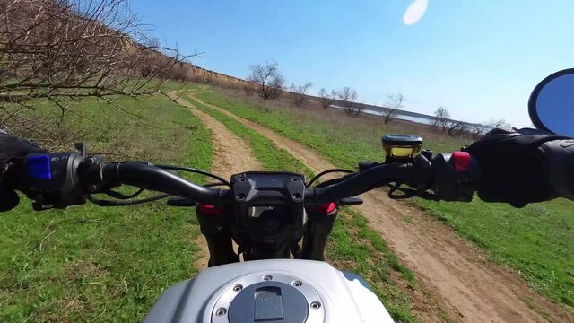 A motorcyclist rides along a trail with a beautiful landscape. View from behind the wheel of a motorcycle. First-person view. POV. The view of a biker riding through scenic nature. 