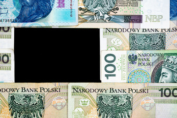 Polish banknotes of PLN 100 and PLN 50 on a black background. Photo taken under soft artificial light