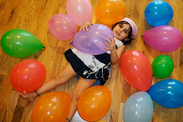 Baby playing with colorful baloons
