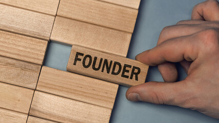 FOUNDER word concept. Close-up wooden piece blocks on the table