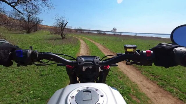 A motorcyclist rides along a trail with a beautiful landscape. View from behind the wheel of a motorcycle. First-person view. POV. The view of a biker riding through a picturesque nature. Slow-motion
