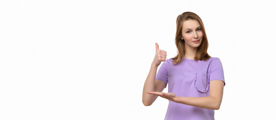 Beautiful young woman wearing casual tshirt showing thumb up gesture and smiling. Place for your text