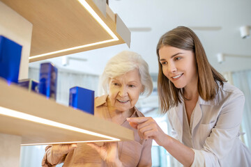 Obraz premium Young dark-haired shop assistant helping a customer to choose a new perfume