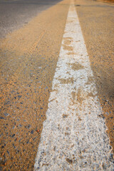 Obraz premium Closeup empty asphalt road with sand and white marking line for given direction. Abstract adventure background concept and transportation idea