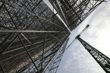 Construction of modern high-rise ski-jump in Shchuchinsk city, Kazakhstan. Tall crane and scaffoldings.