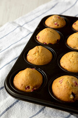 Homemade Cranberry Muffins with Orange Zest in a baking pan, low angle view. Space for text.