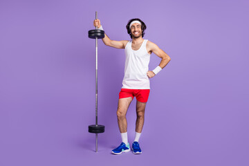 Full length photo of brown haired young crazy man hold hand shtanga good mood isolated on purple color background