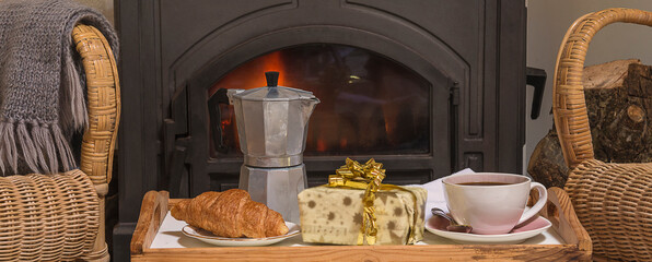 French breakfast with croissants and coffee in front of the burning iron stove