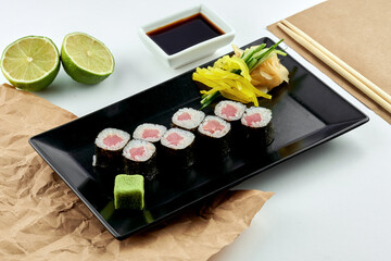 Classic Japanese sushi roll - hosomaki with tuna, served in a black plate. White background. Rolls maki