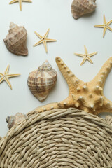 Fototapeta na wymiar Straw bag and seashells on white background