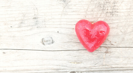 Red heart on natural wooden background as loving heart symbol for wedding greeting card with heart symbol or Valentine's Day card with beautiful red heart