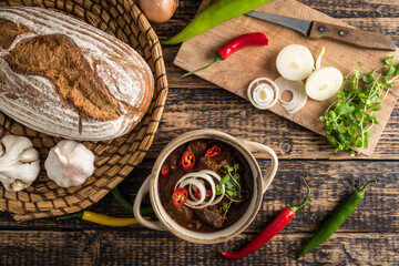 Traditional Hungarian beef goulash with garlic, bread and paprika, garnished with chopped onion and...