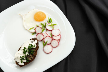 Healthy breakfast, top view. Fried eggs, greens, radishes, baguette with cream cheese.