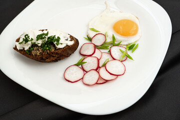 Healthy breakfast, top view. Fried eggs, greens, radishes, baguette with cream cheese.