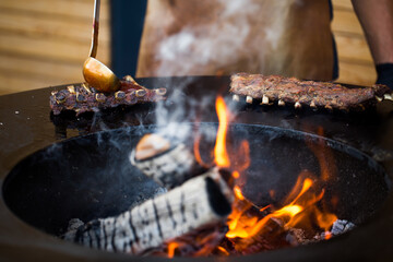 Grilled pork baby ribs with barbecue sauce on the grill. Festival street food