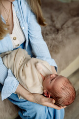 Obraz na płótnie Canvas Little newborn baby boy in mom's arms at home 