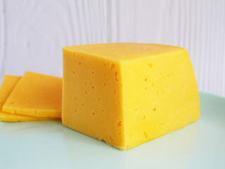 Piece of delicious cheese on a plate isolated on white. close-up.