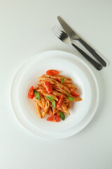 Plate with pasta with tomato sauce on white background