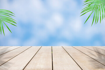 Empty old wooden table in front of abstract blurred beautiful sea and blue sky and fresh coconut green leaf background. Can be used for display or montage for show your products.