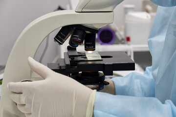 doctor performing a blood test on a microscope