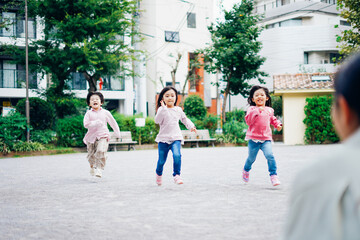 Obraz premium かけっこをする子どもたちとお母さん