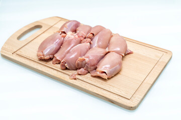 raw chicken thigh flesh on a wooden cutting board