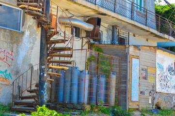 Old building facade and stairwell, eroded by time and vandalised with graffitty at Vama Veche, Romania, July 2020 - obrazy, fototapety, plakaty