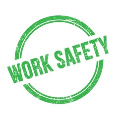 WORK SAFETY text written on green grungy round stamp.