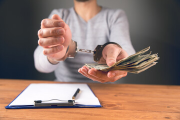 handcuffed gives money