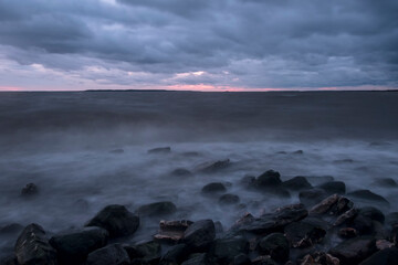 Obraz premium mystical foggy sea and rocky shore in the evening