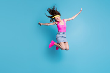 Obraz premium Photo of impressed sweet young lady wear pink singlet jumping high arms sides isolated blue color background